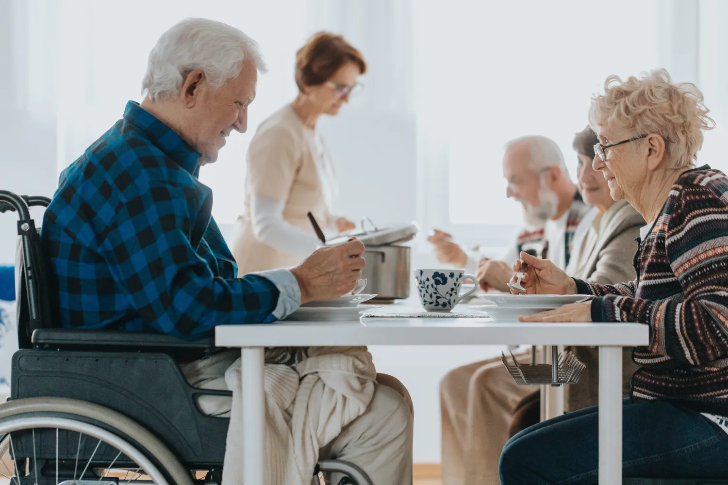 Group of senior people in day-care center eating the dinner together